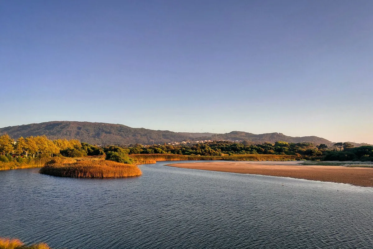 Rio a correr por uma paisagem tranquila ao pôr do sol