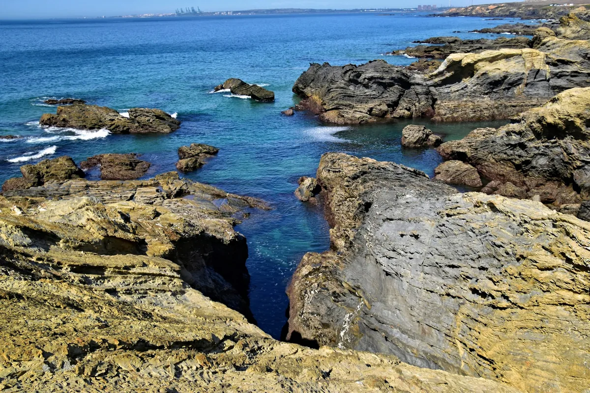 Costa rochosa batida por água oceânica limpa